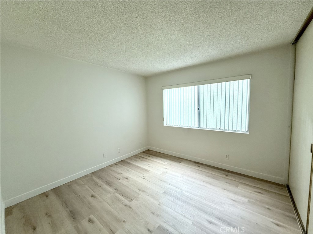 1301 South Atlantic Boulevard, Unit 234C Monterey Park, CA 91754 - Photo 21 of 27 an empty room with wooden floor and windows