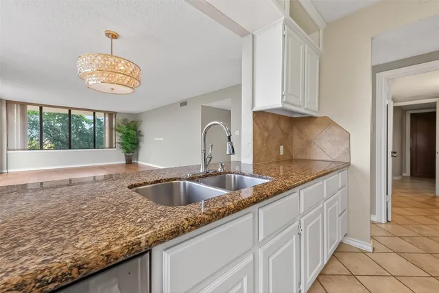 a kitchen with granite countertop a sink and a window
