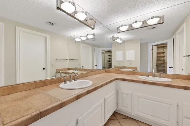 a bathroom with a sink double vanity granite and a mirror