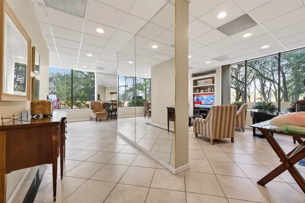 a living room with furniture a flat screen tv and a large window