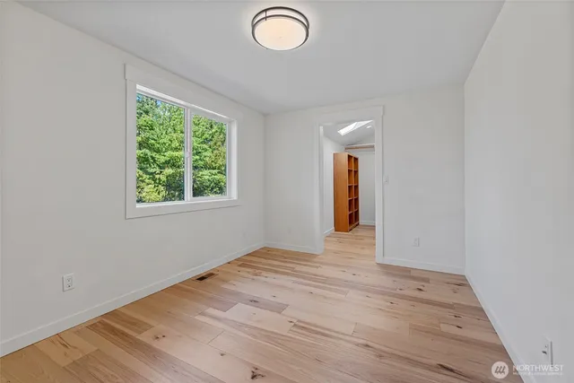 a spacious bedroom with a bed a couch and a flat screen tv