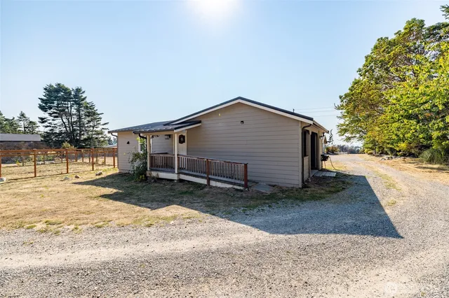 a living room with couches and kitchen view with wooden floor