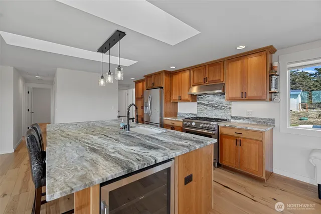 a kitchen with kitchen island a sink stove and refrigerator