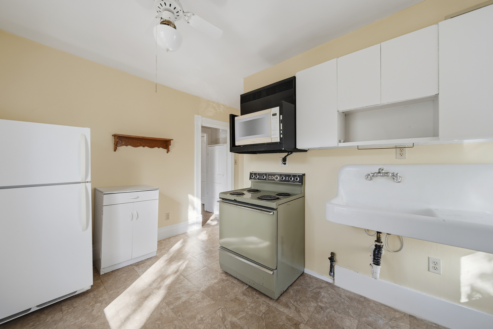 1102 West 3rd Street Dixon, IL 61021 - Photo 32 of 32 a kitchen with a stove top oven and refrigerator