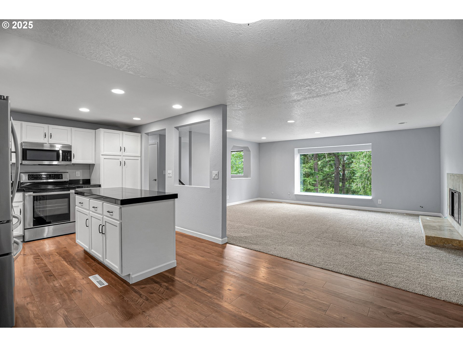 22486 South Redland Road Estacada, OR 97023 - Photo 15 of 46 a kitchen with stainless steel appliances granite countertop a stove a refrigerator a sink a microwave and white cabinets with wooden floor