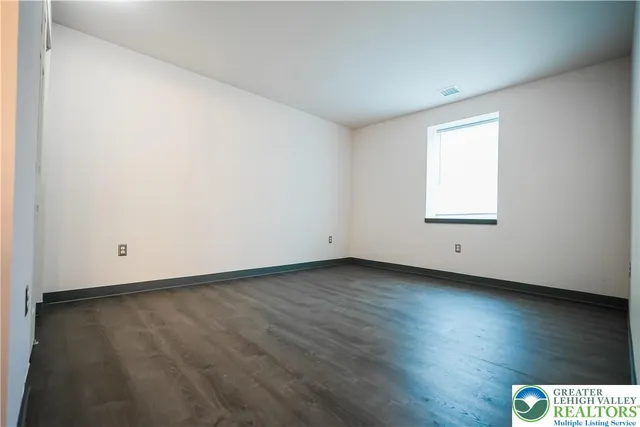 an empty room with wooden floor & closet area