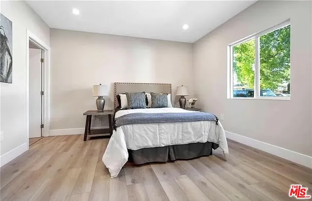 a bedroom with a bed and wooden floor