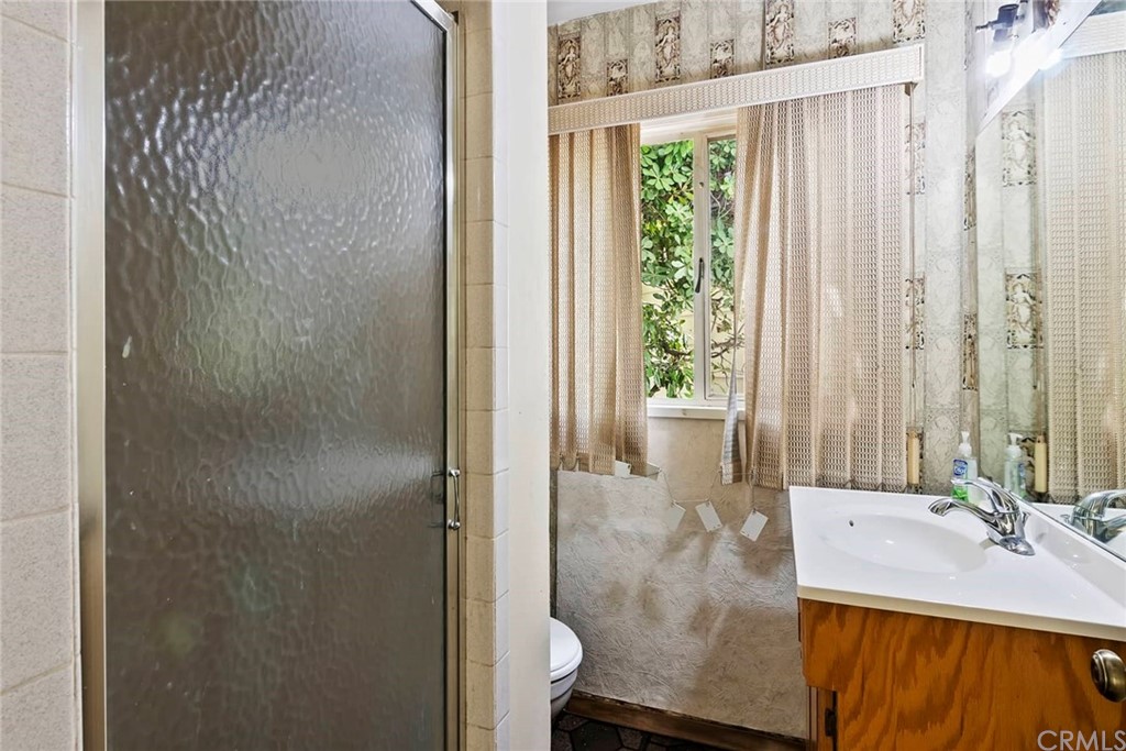 1620 Puebla Drive Glendale, CA 91207 - Photo 27 of 34 a bathroom with a granite countertop sink a mirror and a shower