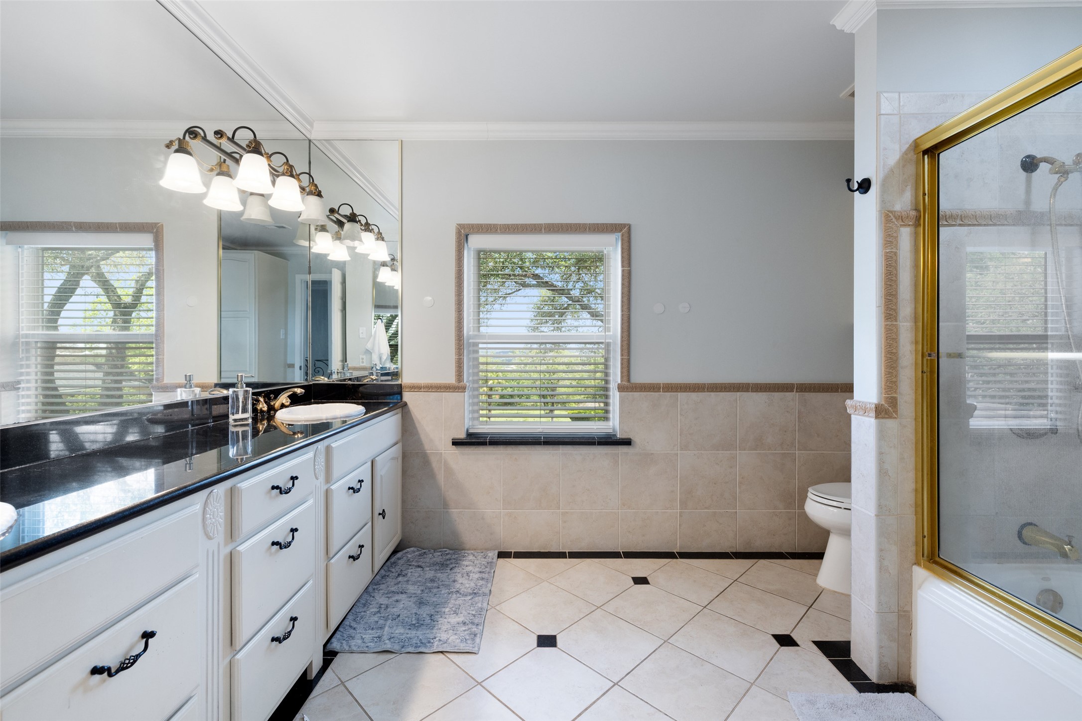 17700 North Rim Drive Leander, TX 78641 - Photo 25 of 38 Full bathroom with tile walls, tile patterned floors, ornamental molding, toilet, and vanity