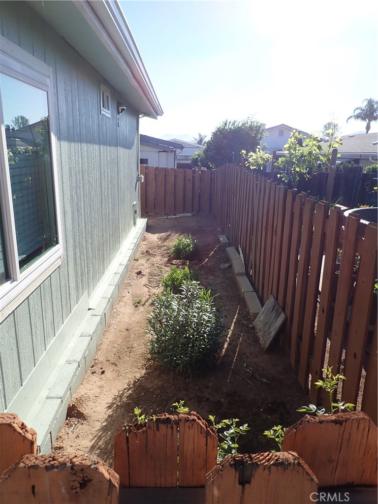 27250 Murrieta Road, Unit 386 Menifee, CA 92586 - Photo 30 of 32 a view of a backyard with wooden fence