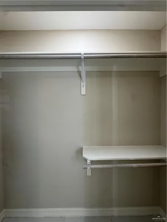 an empty room with windows and ceiling fan