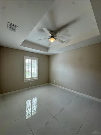 an empty room with a ceiling fan and a window