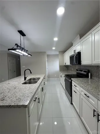 a kitchen with stainless steel appliances granite countertop a sink stove and microwave