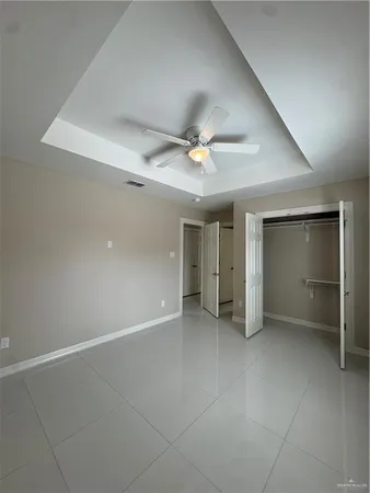 an empty room with a ceiling fan and a window