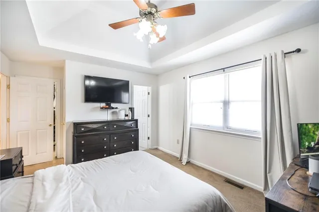 a bedroom with a bed flat screen tv and a chandelier