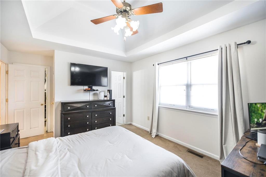 306 Jason Court Macon, GA 31216 - Photo 17 of 30 a bedroom with a bed flat screen tv and a chandelier