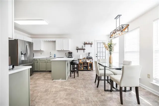 a kitchen with a table chairs refrigerator and cabinets