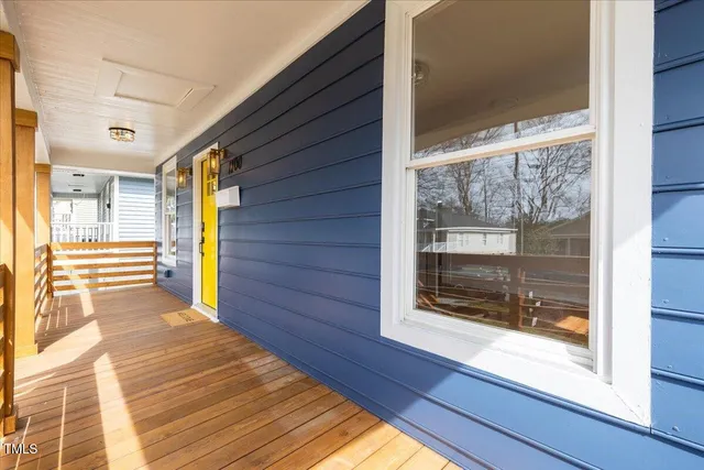 a view of a porch with wooden floor and floor to ceiling window