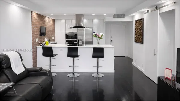 a living room with furniture and a kitchen view