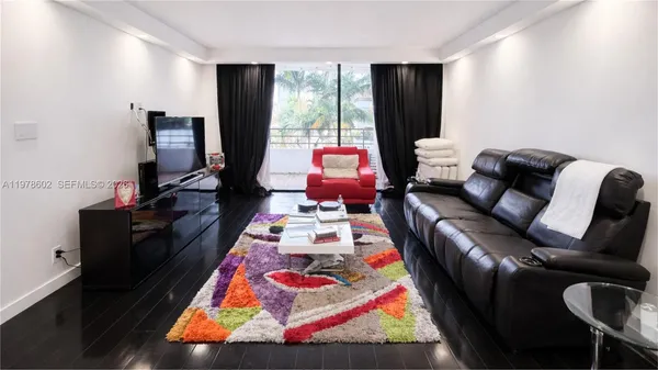 a living room with furniture rug and flat screen tv