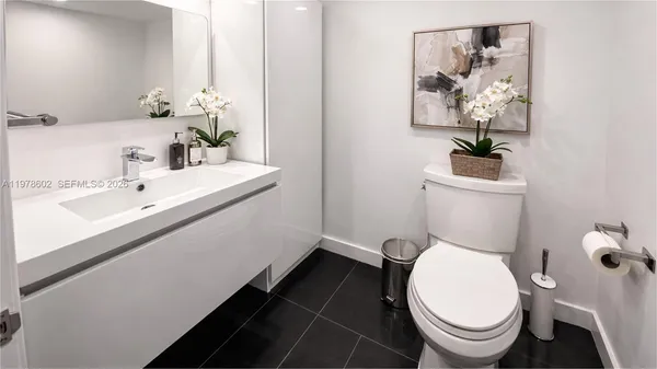 a white toilet sitting next to a bathroom sink