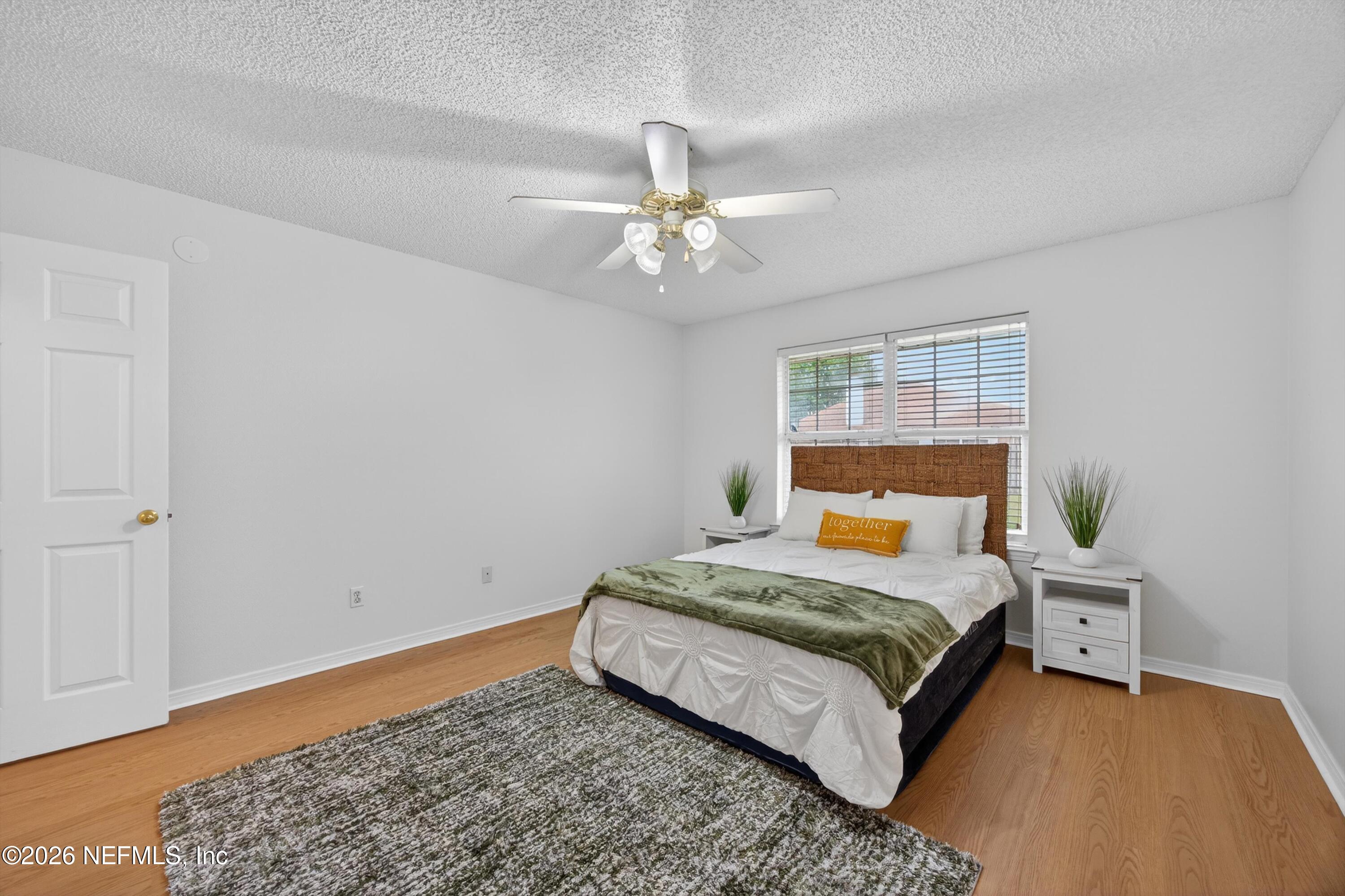 2411 Paris Mill Road Jacksonville, FL 32221 - Photo 24 of 36 a bedroom with a bed and a chandelier
