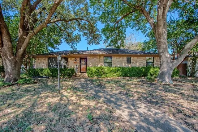 a view of a house with a tree in front of it