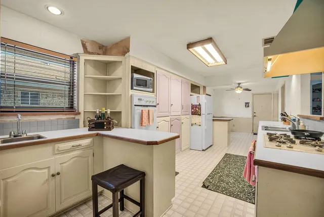 a kitchen with white cabinets and window