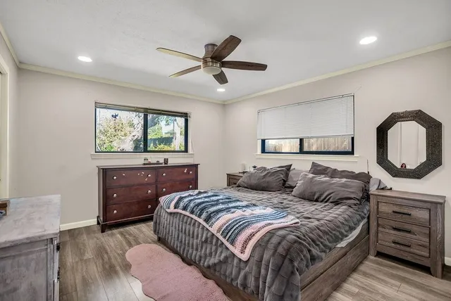 a bedroom with a bed and dresser with mirror