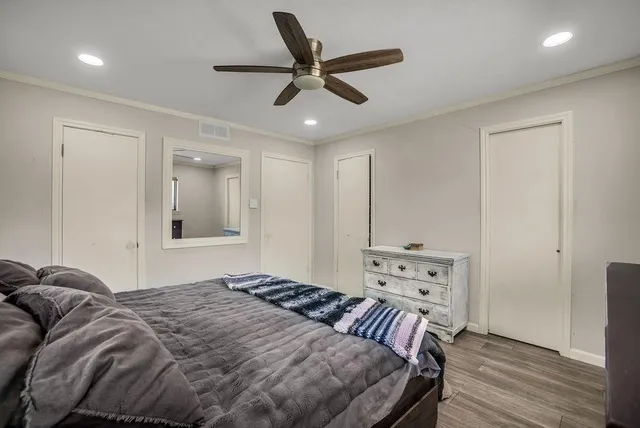 a bedroom with a large bed and a ceiling fan