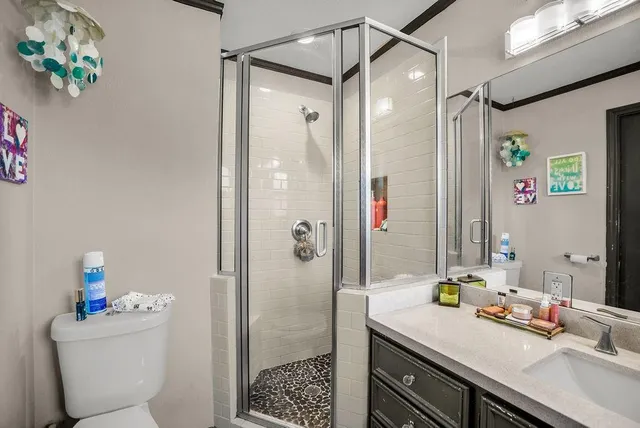 a bathroom with a sink a toilet and shower