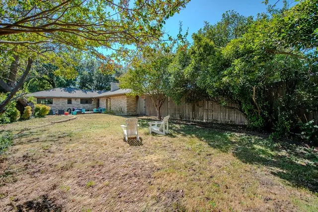 a view of a house with backyard and sitting area
