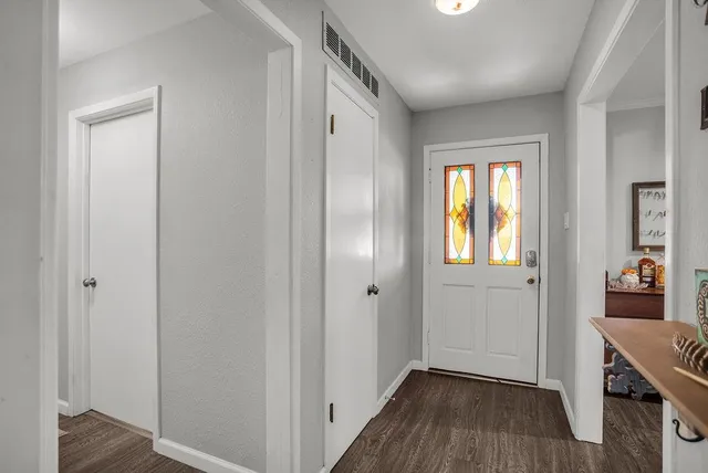 a view of a hallway with wooden floor and closet area