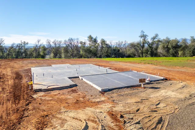 a view of a pool with lawn chairs under an umbrella