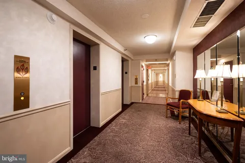 a view of a hallway with furniture and windows