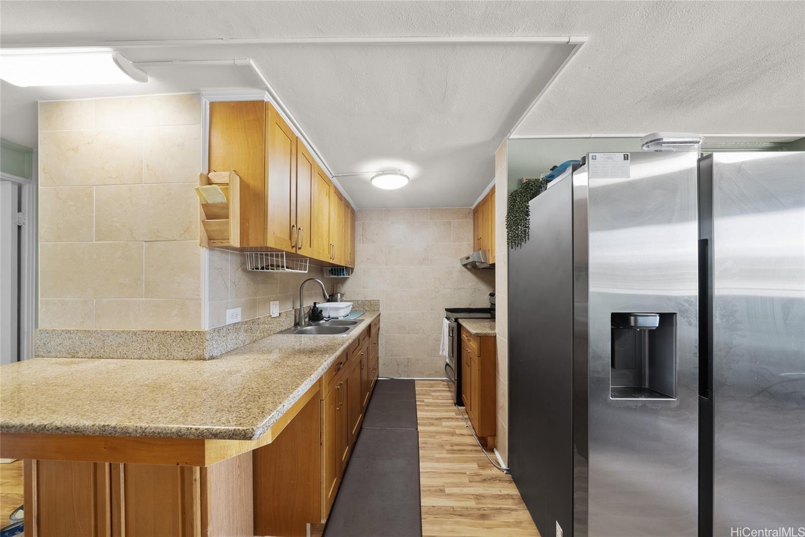 3215 Ala Ilima Street, Unit A510 Honolulu, HI 96818 - Photo 4 of 14 a kitchen with stainless steel appliances granite countertop a sink and a refrigerator