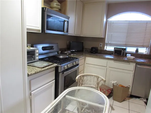 a kitchen with stainless steel appliances granite countertop a refrigerator and a stove
