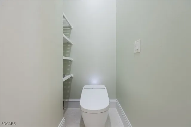 a white toilet sitting next to a white wall
