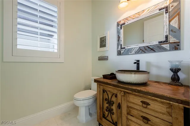 a bathroom with a granite countertop toilet sink and mirror