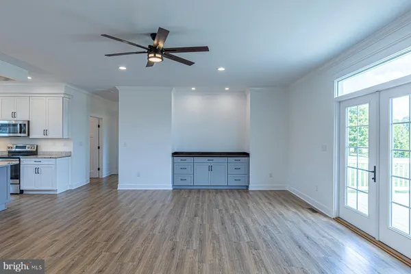 a view of an empty room and window with wooden floor