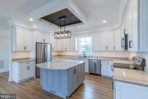a kitchen with stainless steel appliances a sink and wooden cabinets
