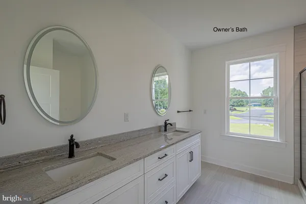 a bathroom with a granite countertop sink a large mirror and a window