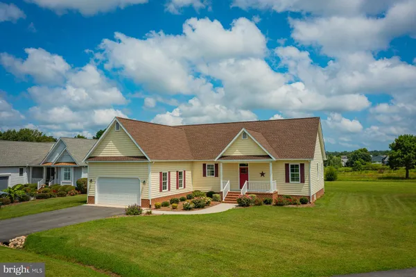 a front view of a house with a garden and yard