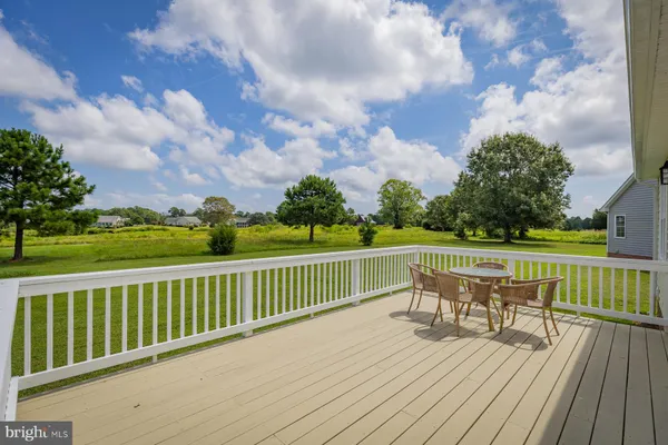 a balcony with wooden floor table and chairs