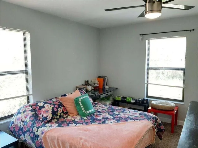 a bed sitting in a bedroom next to a window