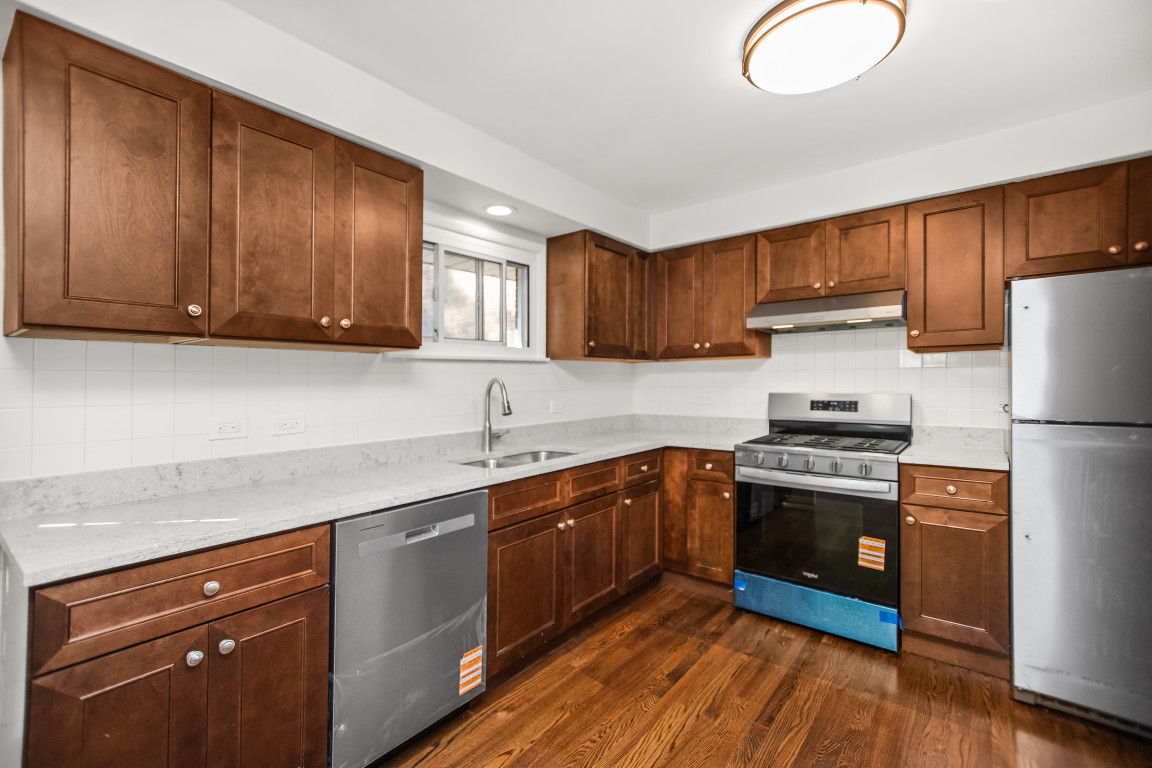 1808 Laurel Avenue Evanston, IL 60201 - Photo 5 of 15 a kitchen with stainless steel appliances granite countertop a stove a sink dishwasher and a refrigerator with wooden cabinets