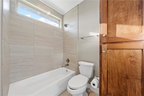a white toilet sitting next to a bath tub and a shower