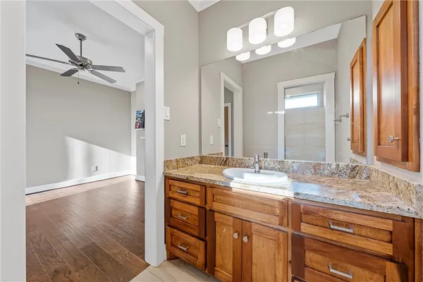 a bathroom with a granite countertop sink a mirror and a shower