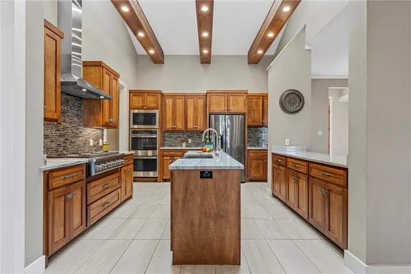 a kitchen with stainless steel appliances granite countertop a stove a sink and a refrigerator