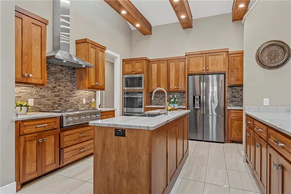 a kitchen with stainless steel appliances granite countertop a refrigerator and a stove top oven